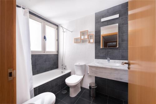 une salle de bain avec des toilettes blanches et un lavabo dans l'établissement Apartamento Benidorm de Luxe, à Benidorm