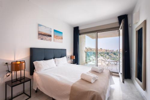 une chambre avec un grand lit et une grande fenêtre dans l'établissement Apartamento Benidorm de Luxe, à Benidorm