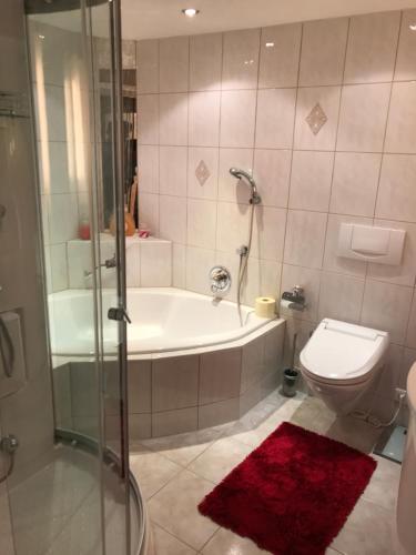 a bathroom with a tub and a toilet and a shower at Neurauter‘s FerienAppart: in Telfs