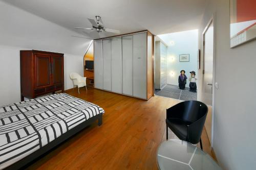 een slaapkamer met een bed en een zwarte stoel bij The Art Residence Maastricht in Maastricht