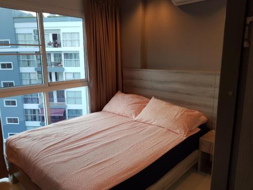 a bedroom with a bed and a large window at Grandblue condominium 609 in Mae Pim