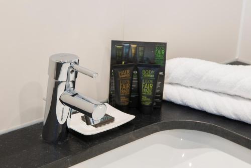 a bathroom sink with a faucet and books on a counter at Fletcher Hotel-Restaurant de Wageningsche Berg in Wageningen