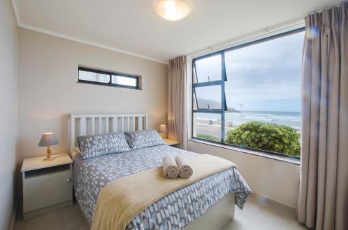 a bedroom with a bed and a large window at Herolds Bay Accommodation - Hiers Ons Weer Downstairs in Herolds Bay