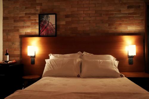 a bedroom with a large bed with two lights at Pousada Santa Thereza in Serra Negra