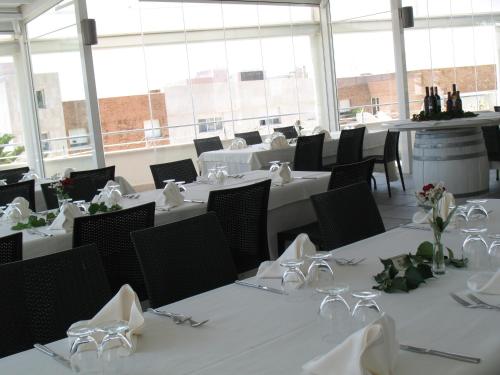 a dining room with tables and chairs with white napkins at Hotel Vittoria in San Giovanni Rotondo