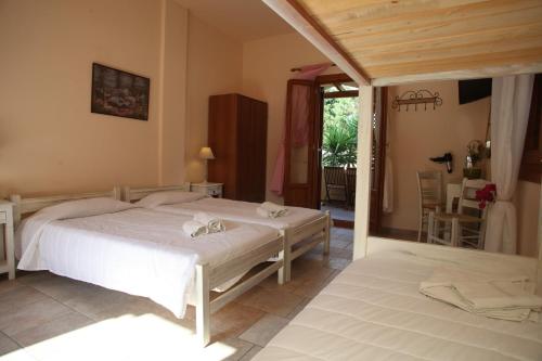 a bedroom with a white bed in a room at Ventoura Studios & Apartments in Galissas