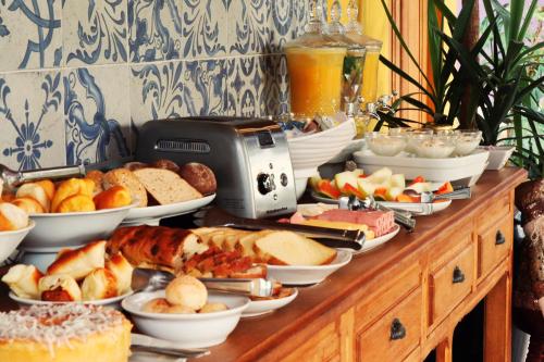 a buffet with many plates of food on a table at Pousada Santa Thereza in Serra Negra