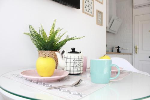 a table with a plate and a vase with a plant at New Central Studio Torremolinos in Torremolinos