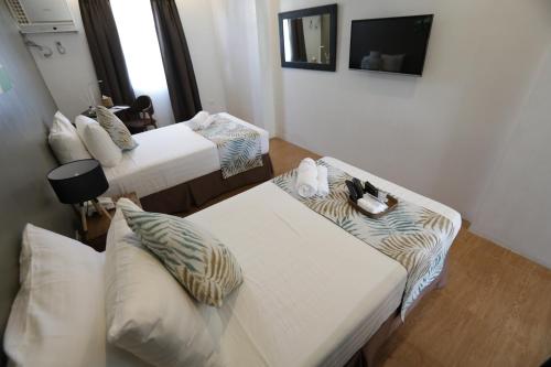 a hotel room with two beds and a couch at Balar Hotel and Spa in Boac