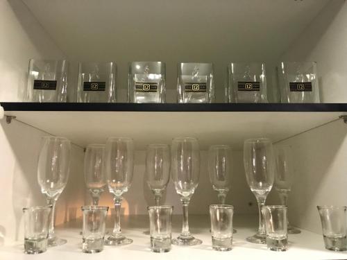 ein paar Weingläser auf einem Regal in der Unterkunft Praia do Forte Apt. in Praia do Forte