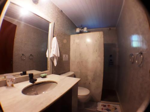W łazience znajduje się umywalka, toaleta i lustro. w obiekcie Pousada Alicia w mieście Búzios