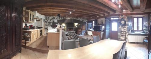 une grande cuisine avec un mur en pierre dans l'établissement Le Cottage Lavastrie, à Lavastrie