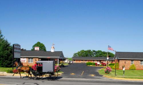 a horse drawn carriage in front of a building at Weathervane Motor Court in Ronks