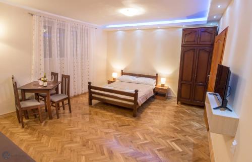 a bedroom with a bed and a table and a television at Apartments Vila Marija in Kotor