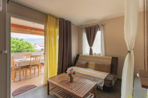 a bedroom with a bed and a table and a balcony at La Kazette - Votre Studio de Vacances à l Île de La Réunion in Saint-Louis