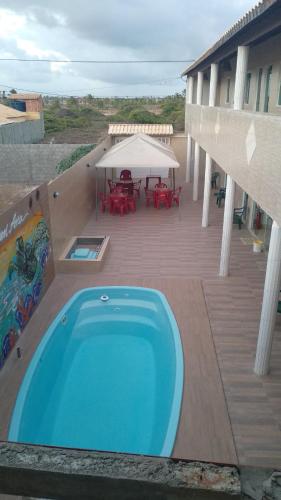 a large pool on a deck with a table and chairs at Pousada Don'Ana in Conde