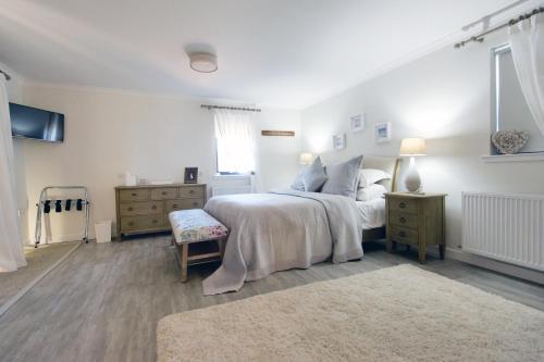 a bedroom with a bed and a dresser and window at Dunnet B&B Escapes in Dunnet