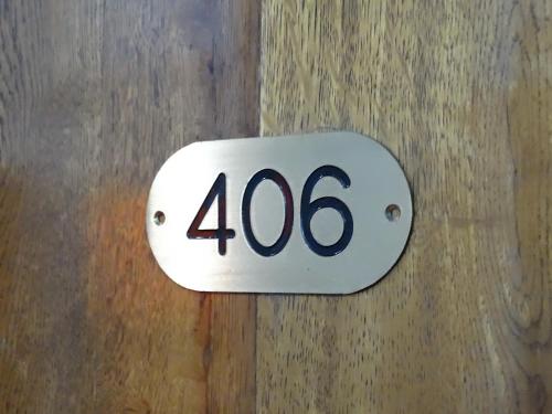 a house number sign on a wooden door at Garden Palase Hotel in Fier