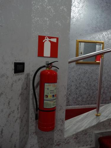 a red fire hydrant in a bathroom with a mirror at Garden Palase Hotel in Fier