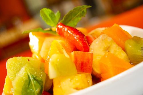 a white bowl filled with fruit and vegetables at Ambrózia Étterem és Panzió in Kazincbarcika
