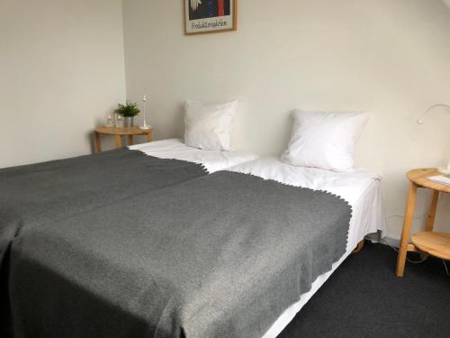 a bedroom with a large bed with white sheets and pillows at Tune Kursuscenter in Greve