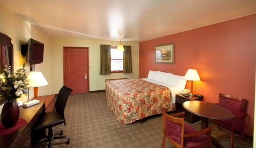 隆克斯的住宿－風向標汽車旅館，酒店客房带一张床、一张桌子和椅子
