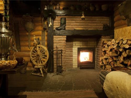 a living room with a fireplace in a log cabin at Sobi Hotel in Vyshhorod