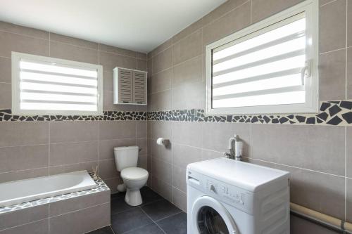 a bathroom with a washing machine and a toilet at La Kazette - Votre Studio de Vacances à l Île de La Réunion in Saint-Louis