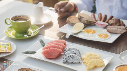 a table with two plates of food and a cup of coffee at Tube Resort by EHM in Koh Rong Sanloem