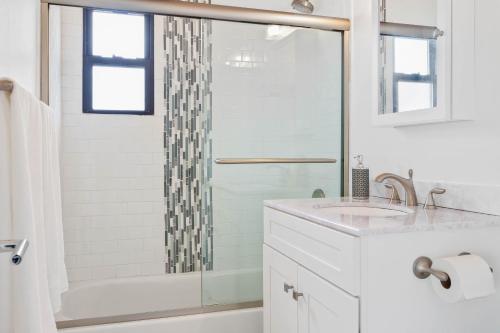 Un baño blanco con ducha y lavabo. en 26 Duneway, en Ocean Beach