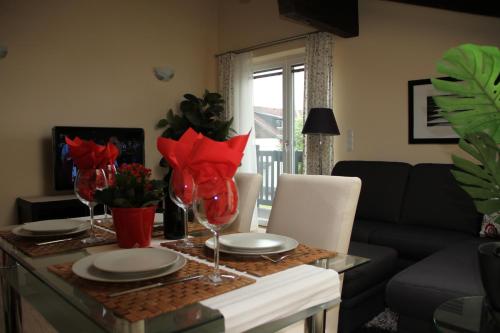 a dining room table with red flowers on it at Alpenlandhaus Menardi in Seefeld in Tirol