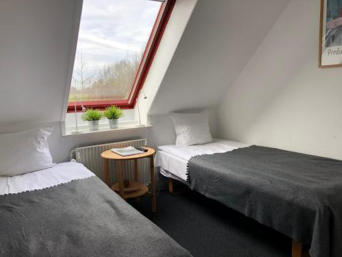 2 camas en una habitación pequeña con ventana en Tune Kursuscenter, en Greve