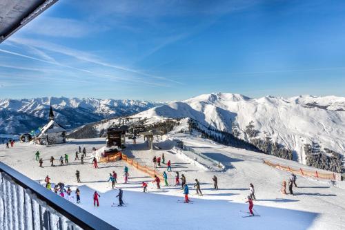 a group of people on a ski slope in the snow at Berghotel Schmittenhöhe - 2000m in Zell am See