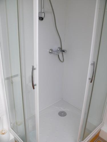 a shower with a glass door with a shower head at Hôtel Le Vivier WISSANT - Centre Village - Côte d'Opale - Baie de Wissant - 2CAPS in Wissant