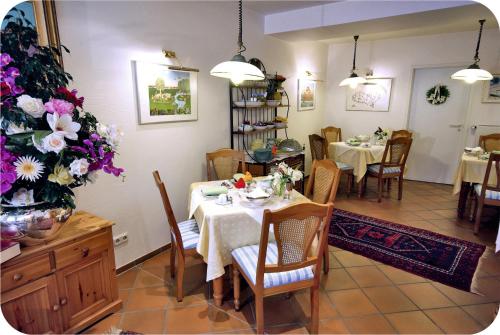 een eetkamer met een tafel en stoelen en bloemen bij Haus Berlin in Kaub
