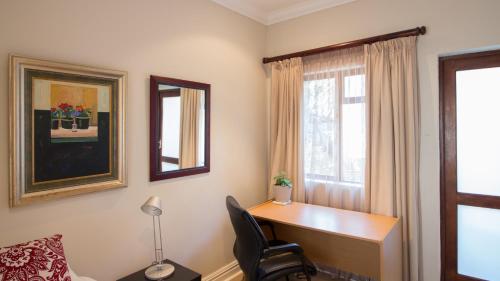 a room with a desk and a chair and a window at Manor 38 in Port Elizabeth