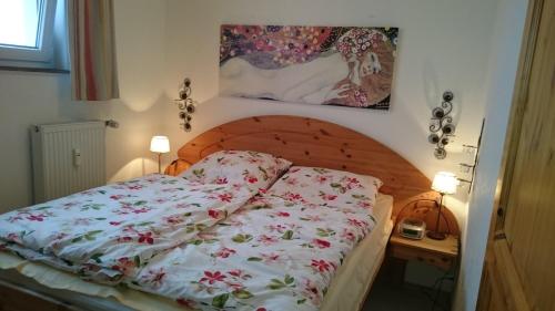a bedroom with a bed with a floral comforter at Ferienwohnung "Traumblick" - Selbstversorger in Braunlage