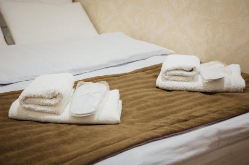 a bed with white towels on top of it at TB Apart-Hotel in Tbilisi 1 in Tbilisi City
