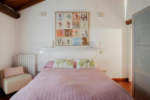 Un dormitorio con una cama con un edredón rosa y una silla. en Appartamento San Michele, en Milán