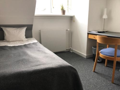 a bedroom with a bed and a desk and a chair at Tune Kursuscenter in Greve