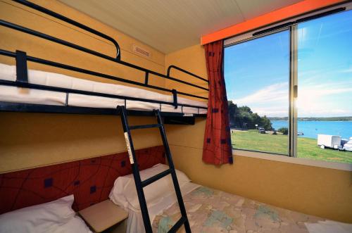 um beliche num quarto com uma janela em Arena Tasalera Mobile Homes em Premantura