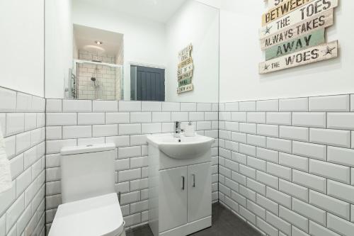 een witte badkamer met een wastafel en een toilet bij Park House - Large 3 Bedroom Victorian House, 10 Mins from Manchester in Manchester