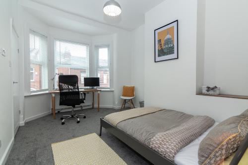 een slaapkamer met een bed en een bureau met een computer bij Park House - Large 3 Bedroom Victorian House, 10 Mins from Manchester in Manchester