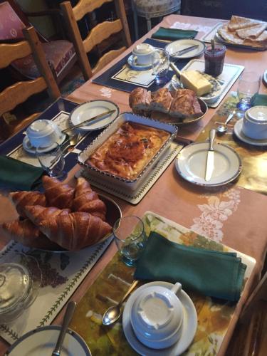 einen Tisch mit Speisen, Croissants und Brot darauf in der Unterkunft lantrennou in Feunteun-Ven