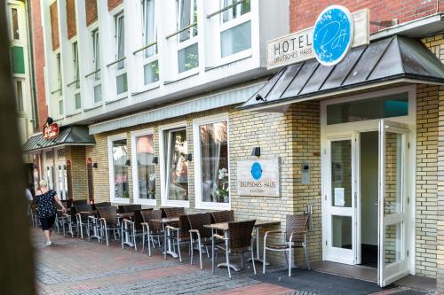 a row of tables and chairs outside of a restaurant at Hotel DH -Deutsches Haus- in Emden