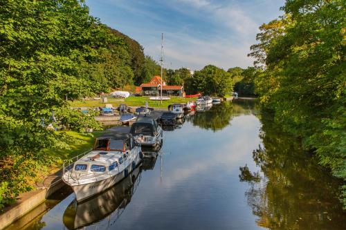 a group of boats are docked in a river at Hotel DH -Deutsches Haus- in Emden