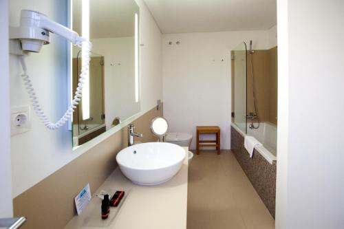 a white bathroom with a sink and a toilet at Convento Da Serta Hotel in Sertã