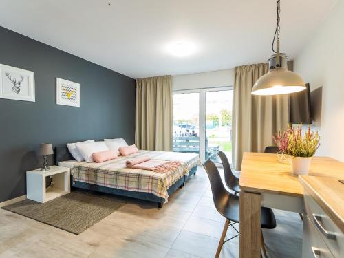 Un dormitorio con una cama y una mesa y un comedor. en Laba, en Mrzeżyno