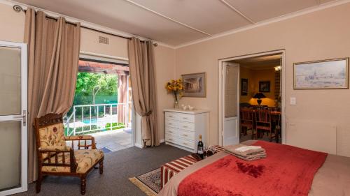a bedroom with a red bed and a balcony at Brown Jug Guest House in Hermanus
