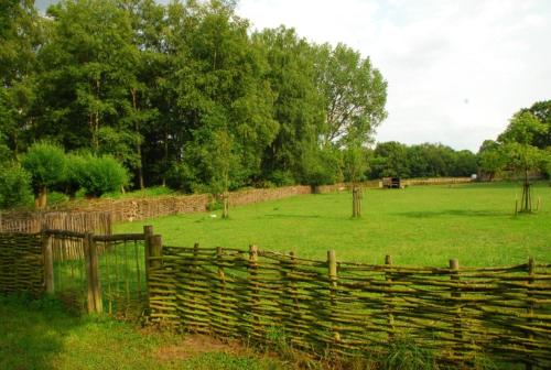 a fence in a field next to a field at De Oude Molen in As